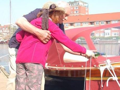 Zu sehen ist eine ältere Dame, welcher auf das Boot Falderndelft geholfen wird