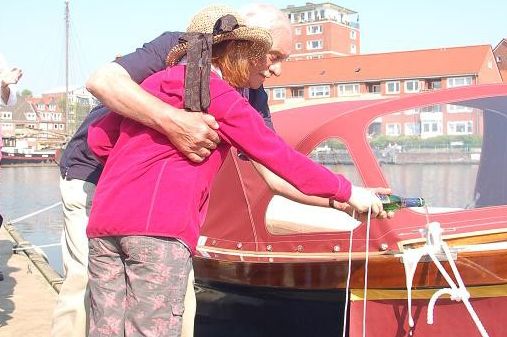 Zu sehen ist eine ältere Dame, welcher auf das Boot Falderndelft geholfen wird